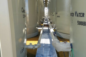 Tanks in oil field with pads from Specified Containment